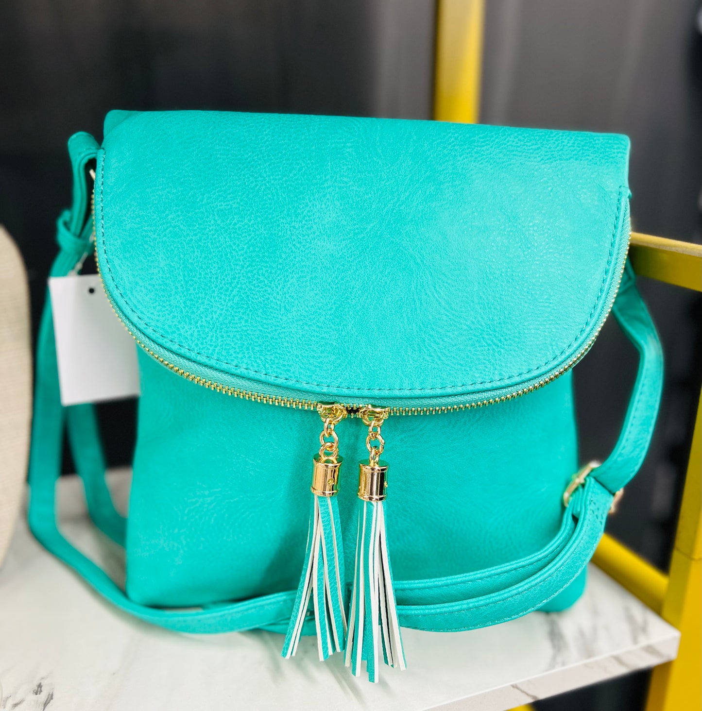 TASSEL ACCENT ROUND FLAP CROSSBODY